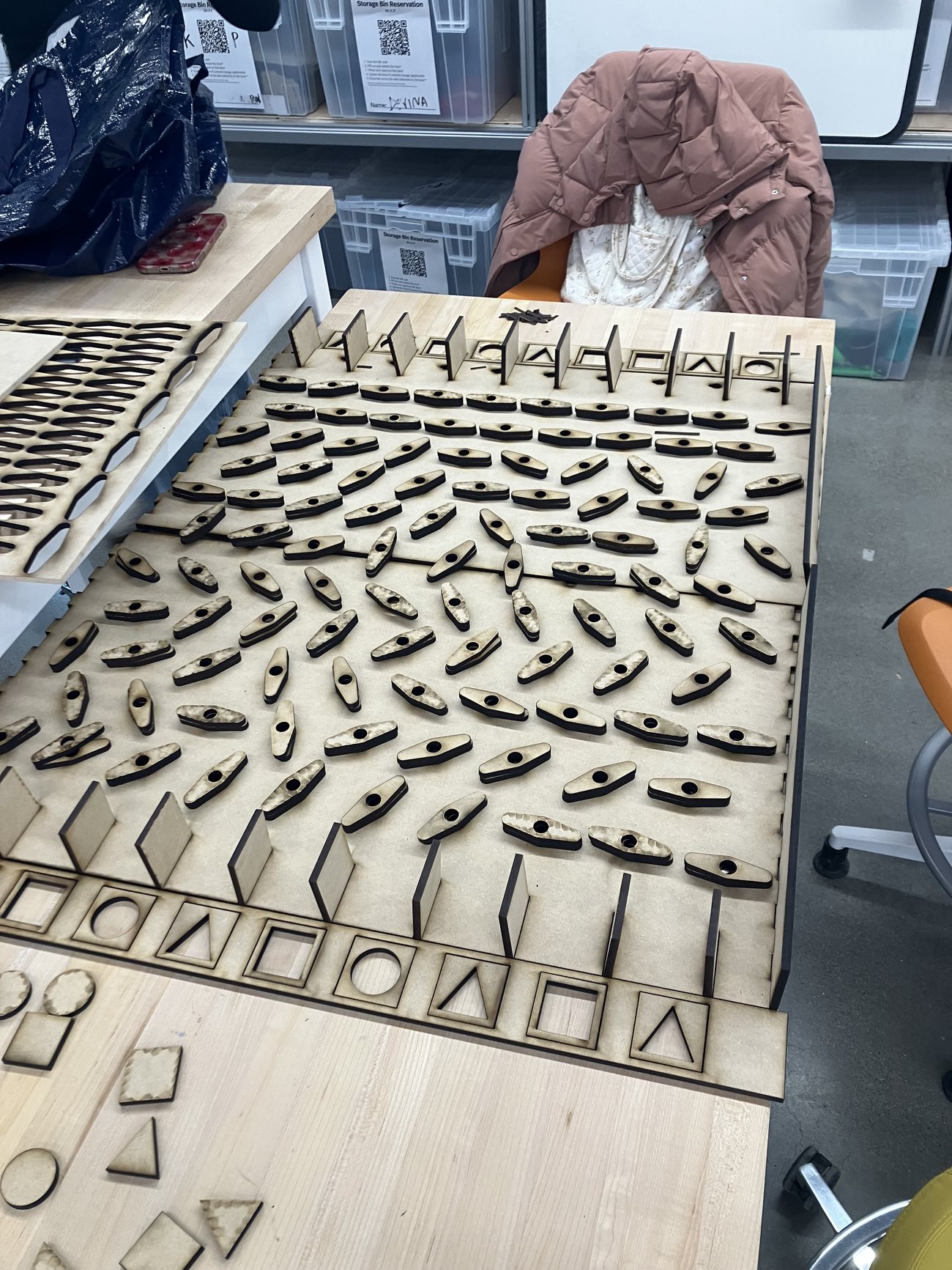The laser-cut board showing the staggered grid of paddles and the shaped entry and exit slots