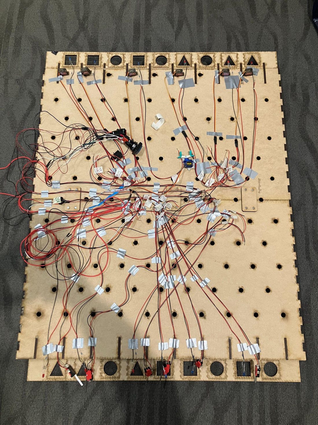 The back of the board showing the soldered wiring, servos, and limit switches